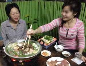 Shirley on the lift with Ticky's girlfriend, enjoying a Lao hot pot.